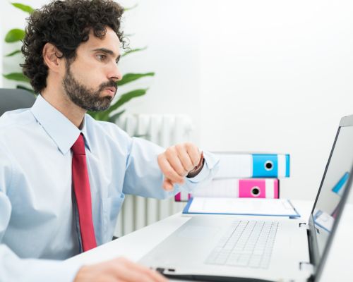 woman sitting infront of laptop at night time looking tired